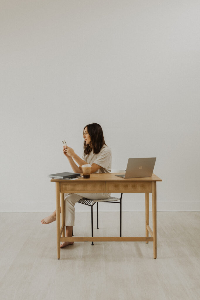 Woman sitting at desk prepping to work on a low-cost website design.